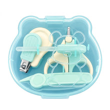 A baby nail care set inside a light blue bear-shaped plastic case, featuring cream-colored tools with mint green accents, including nail clippers, cuticle trimmer, and nail file, on a white background.