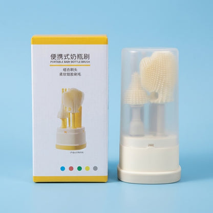 A portable baby bottle brush set shown with its white and yellow retail box on a light blue background. The box reads 'PORTABLE BABY BOTTLE BRUSH' in English and Chinese, and the brush set inside a clear protective case is visible next to it.