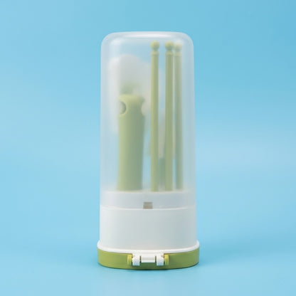 A small cylindrical storage container with a translucent clear top, white base, and light green bottom, holding several pale green tools or accessories, photographed on a smooth light blue background.