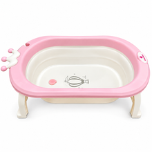 A pink and cream baby bathtub with built-in support legs, a small white hand grip on the left rim, and a hot air balloon graphic printed on the inside bottom.