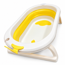 A baby bathtub with a white plastic exterior, a bright yellow interior liner, and a beige fold-out base, shown on a clean white background.